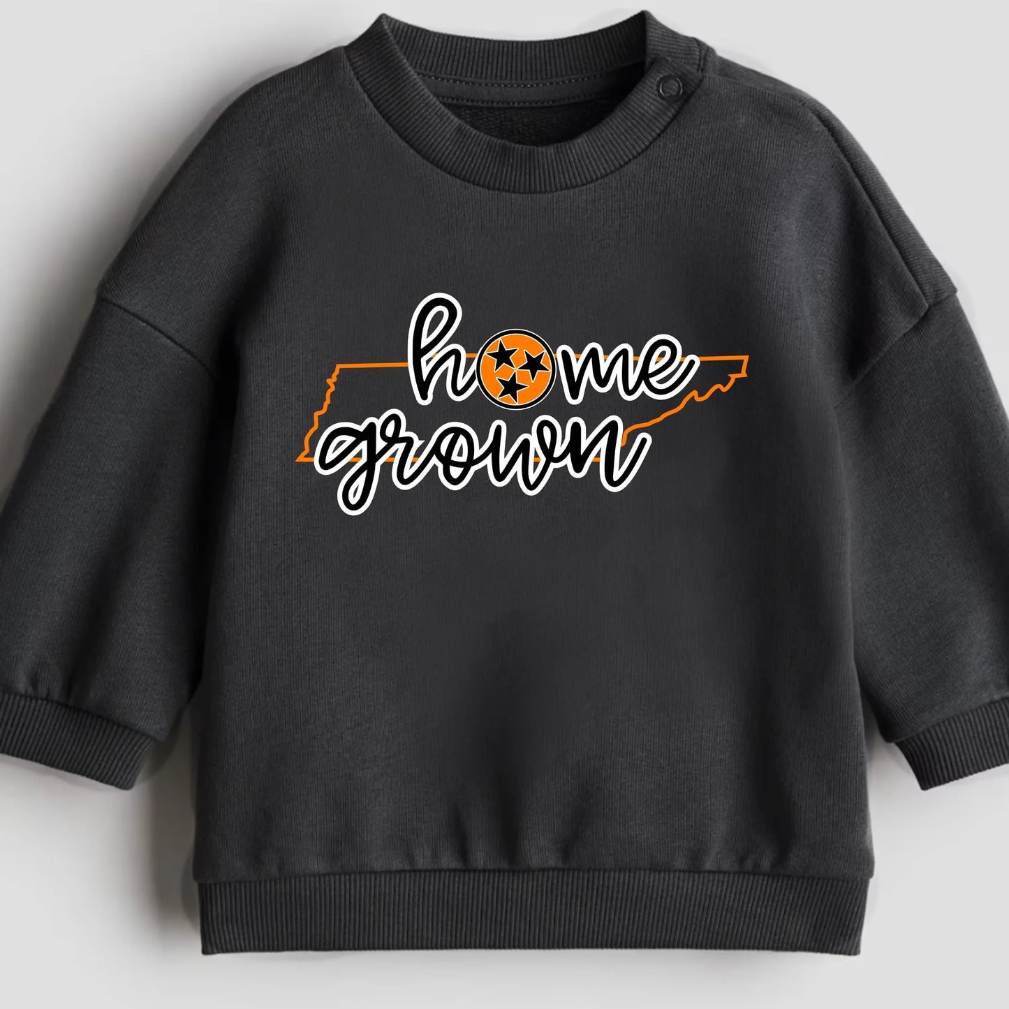 Black sweatshirt with 'home grown' text and a logo on a light gray background