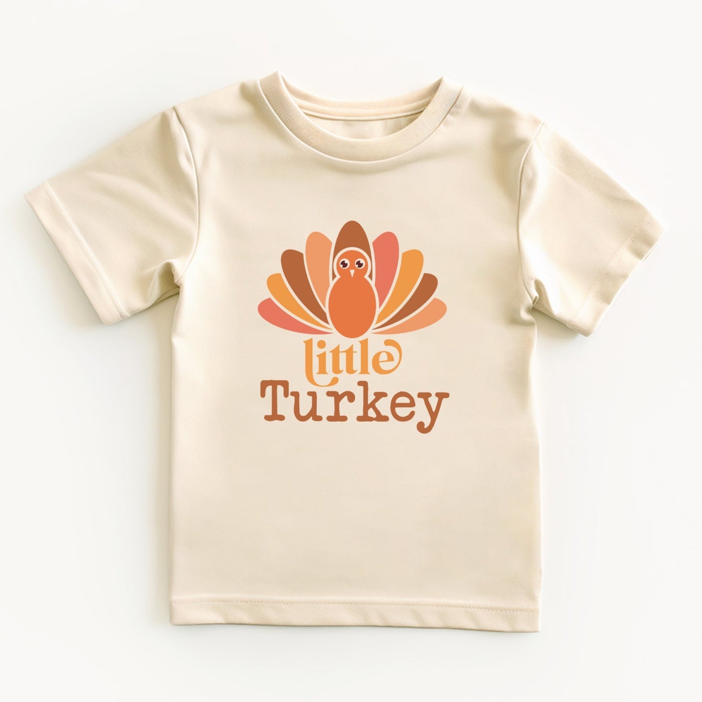 Beige t-shirt with a 'little turkey' graphic on a white background