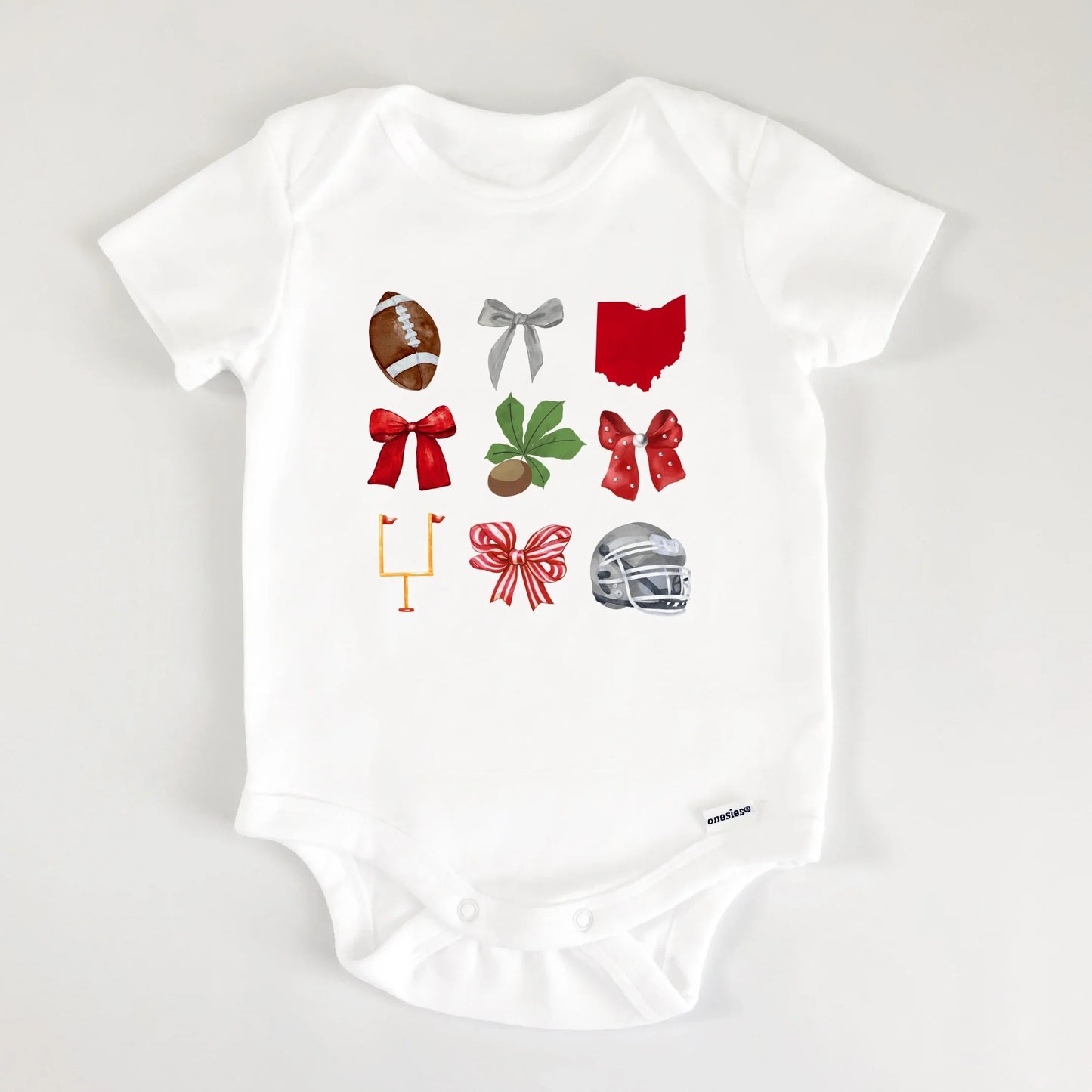 White baby onesie with sports-themed graphics on a light gray background