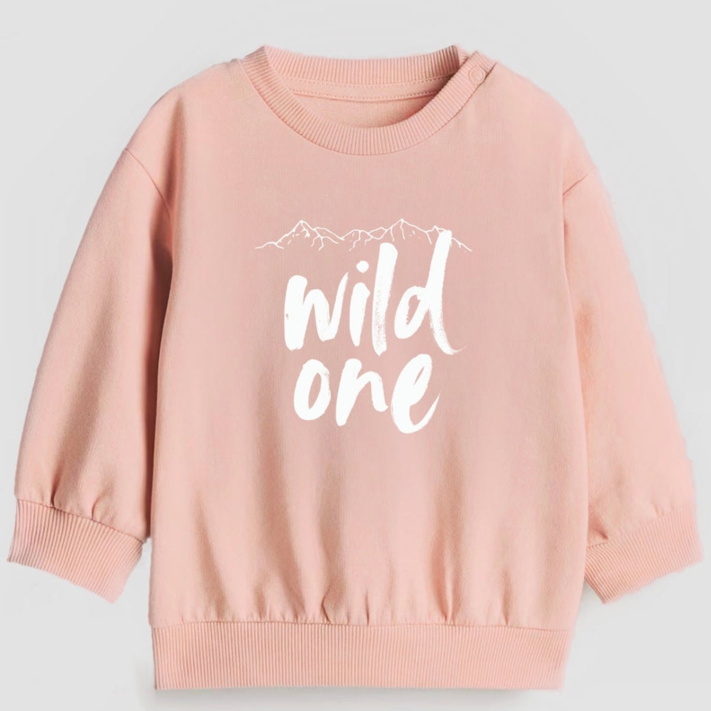 Pink sweatshirt with 'wild one' text on a light gray background