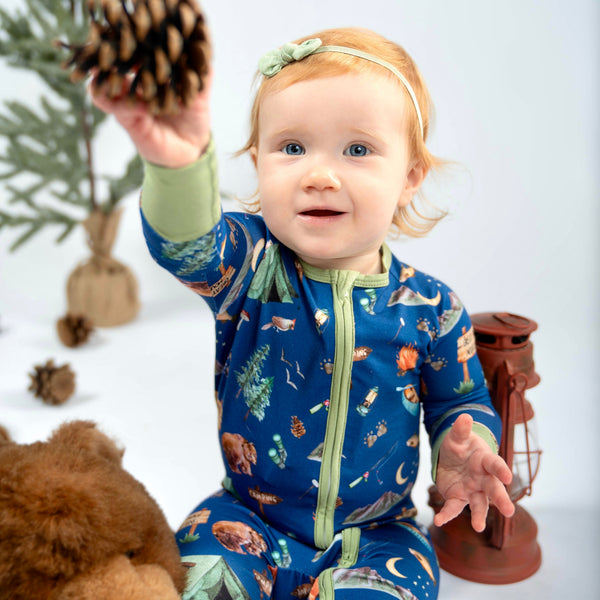 Baby wearing Great Smoky Mountains bamboo zippy pajamas with bears, tents and campfire print
