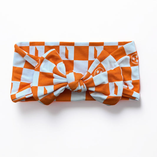 Orange and white checkered headband on a light gray background