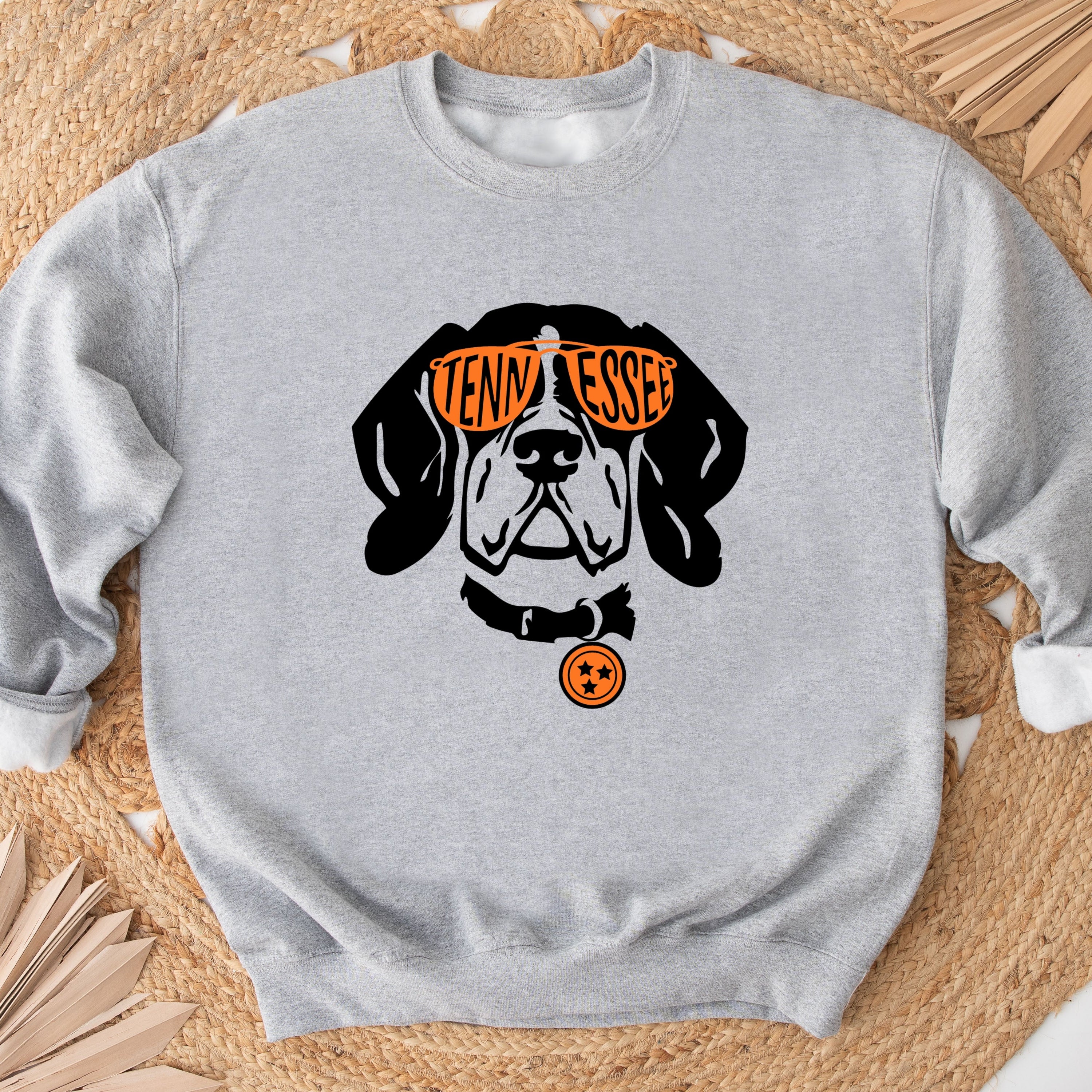 Gray sweatshirt with a dog graphic and 'Vendy Essex' text on a woven mat background