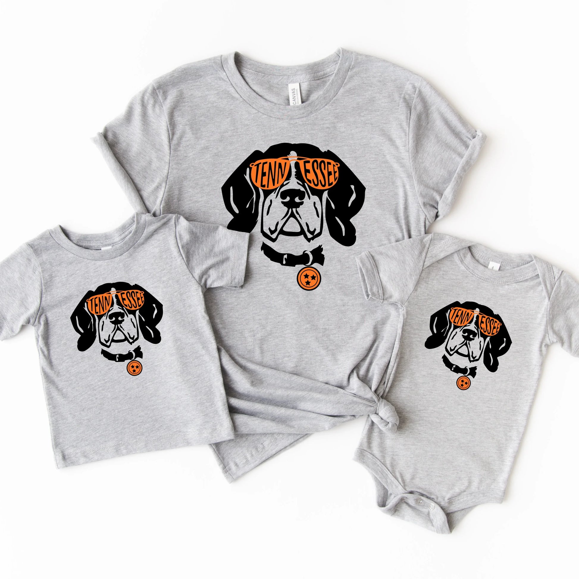 Gray t-shirt with a Tennessee dog graphic and text, paired with a baby onesie on a white background