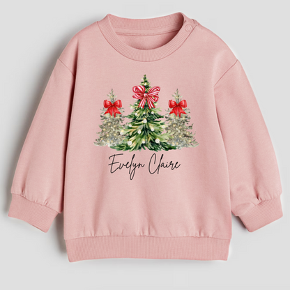 Pink sweatshirt with Christmas tree design and 'Evelyn Claire' text on a light gray background