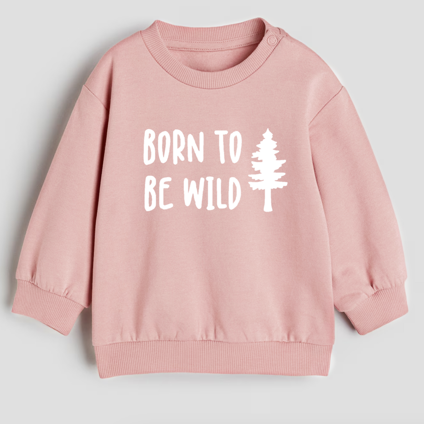 Pink sweatshirt with 'Born to Be Wild' text and tree graphic on a light gray background
