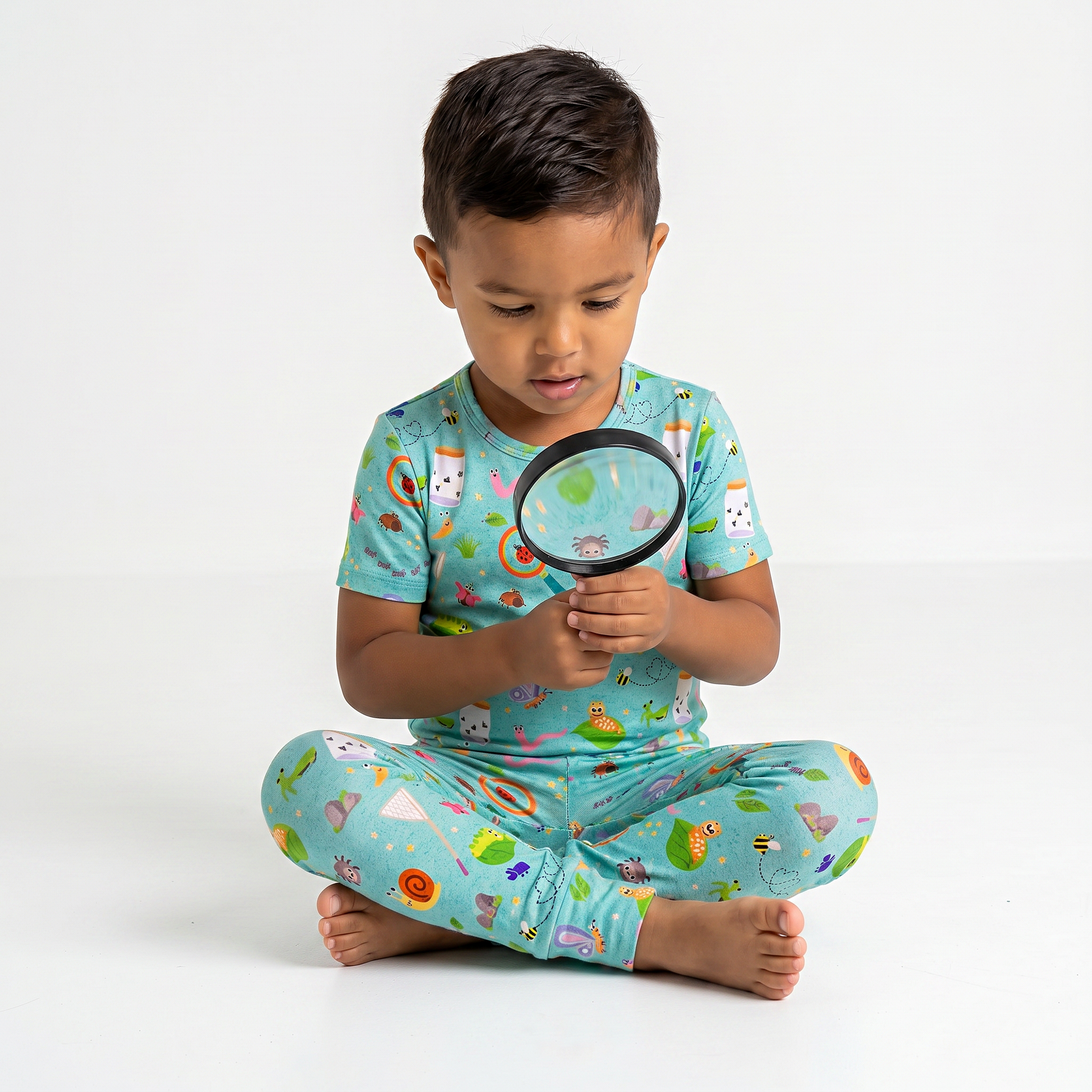 Child wearing a colorful outfit with a magnifying glass on a white background