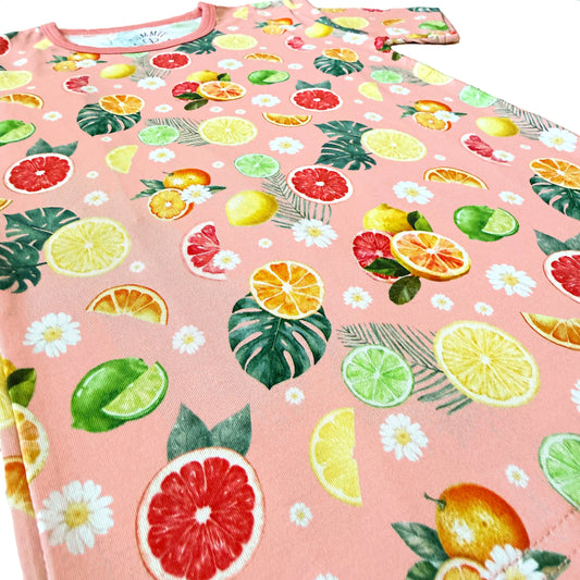 Fabric with colorful fruit and leaf pattern on a pink background