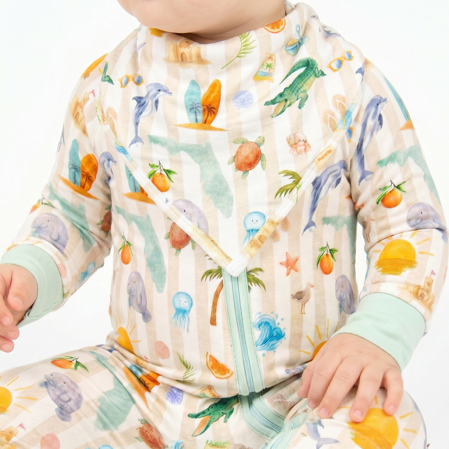 Baby wearing a colorful outfit with marine animal patterns on a white background