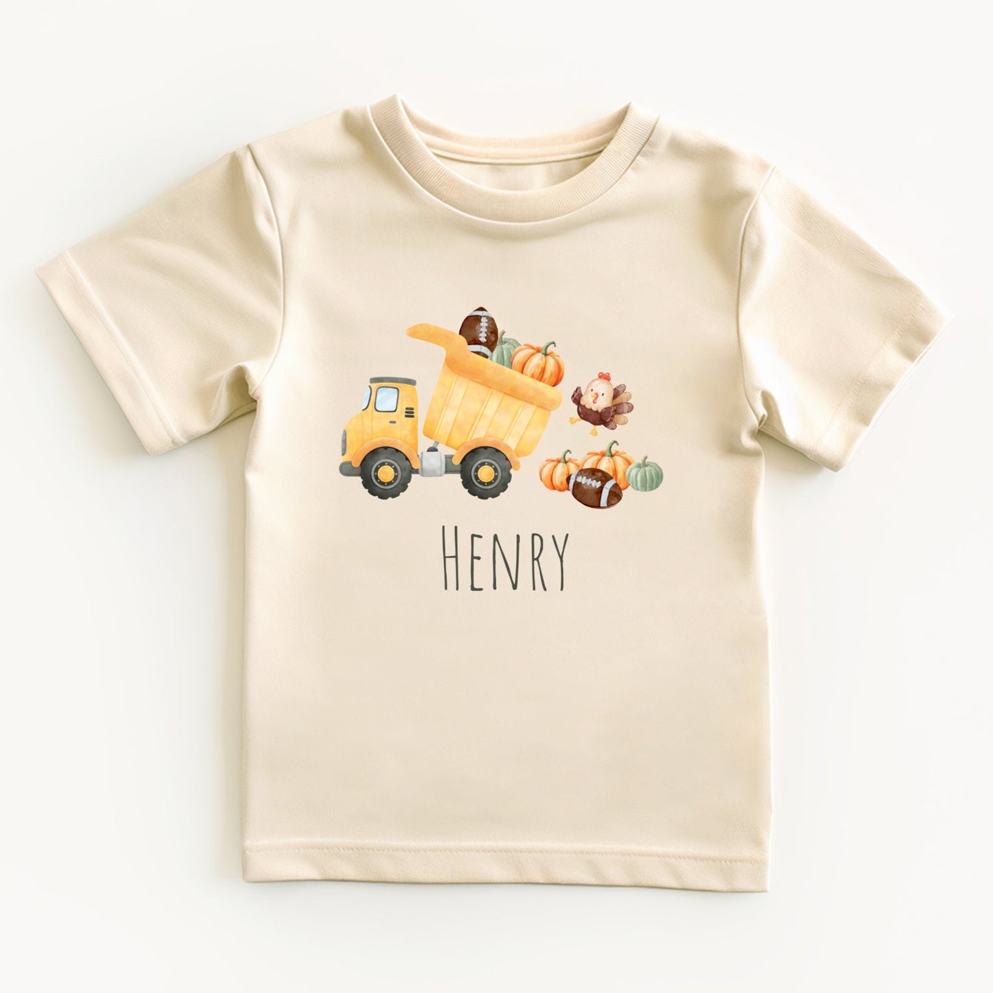 Beige t-shirt with a cartoon dump truck and pumpkins on a white background