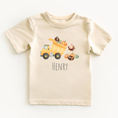 Beige t-shirt with a cartoon dump truck and pumpkins on a white background