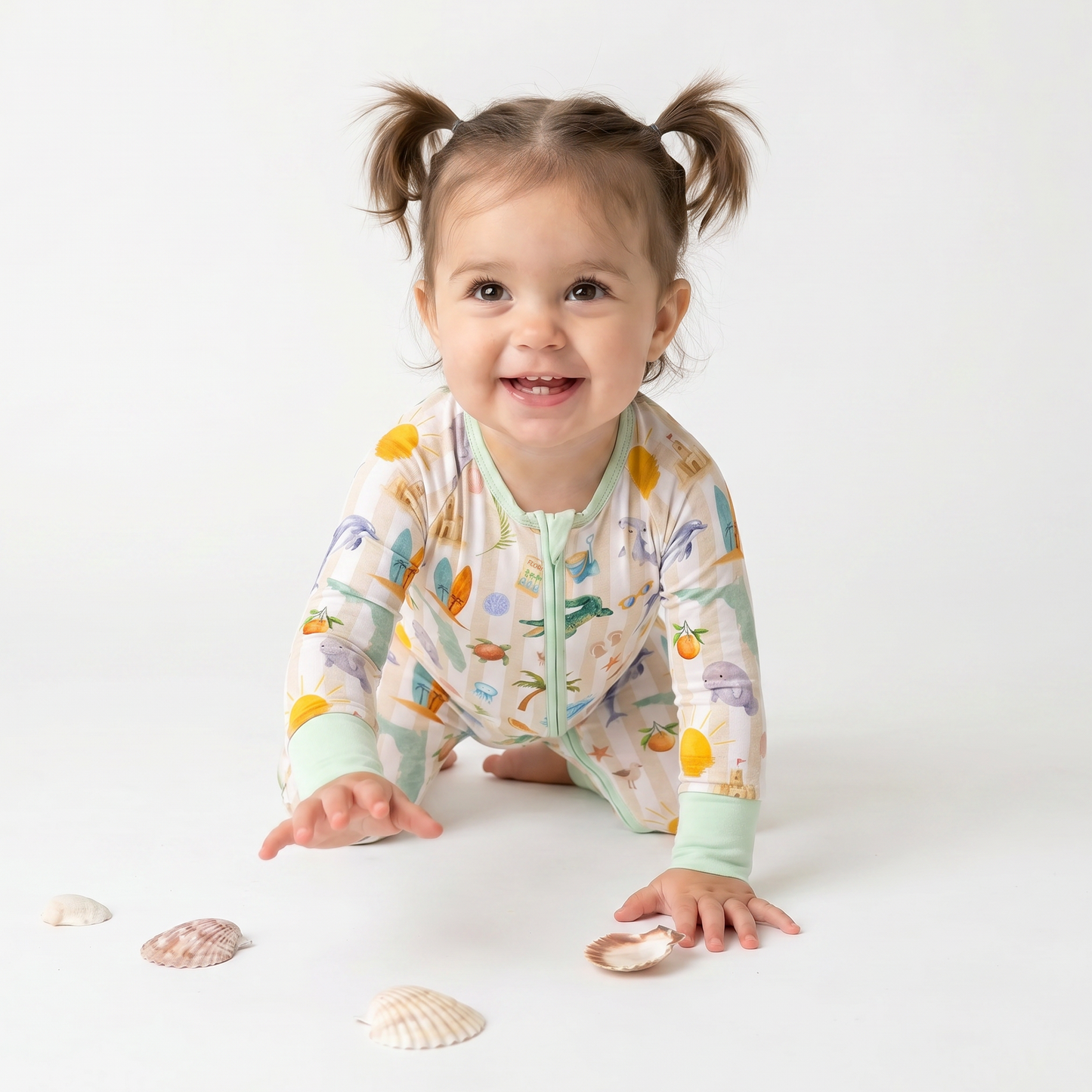 Child wearing a colorful  Florida onesie with sea-themed design on a white background