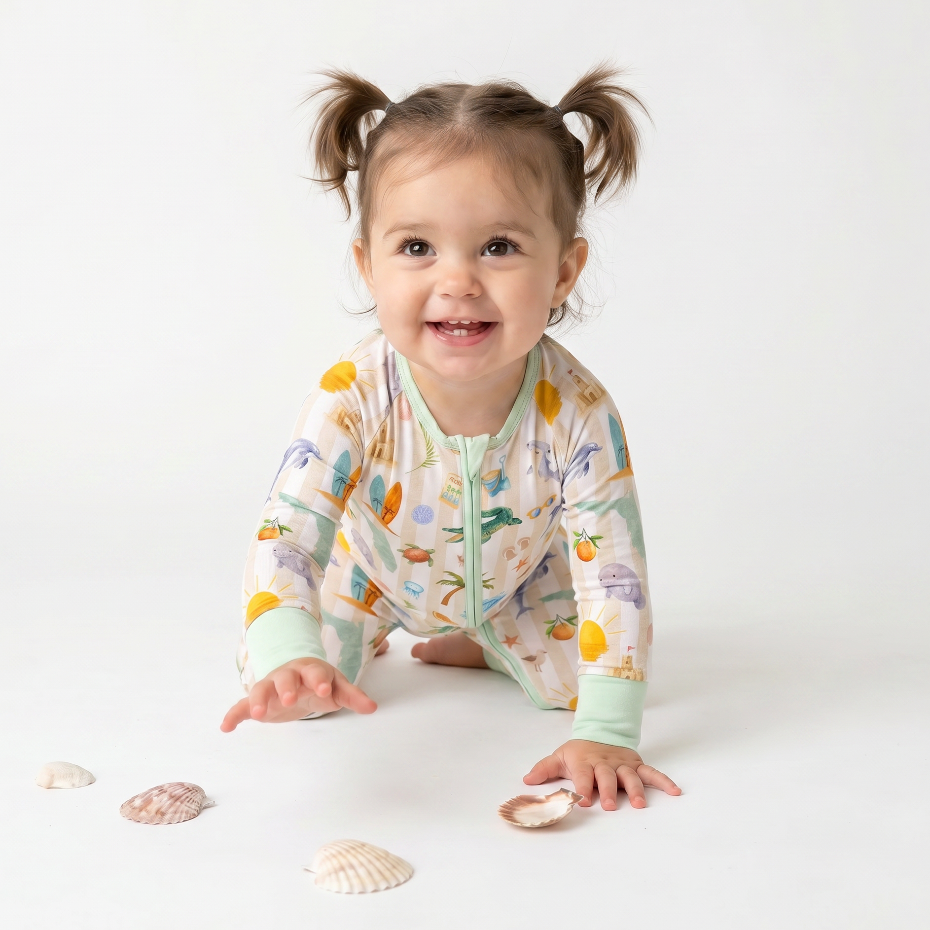Child wearing a colorful  Florida onesie with sea-themed design on a white background