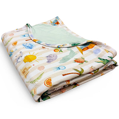 Folded baby blanket with colorful Florida beach pattern on a white background