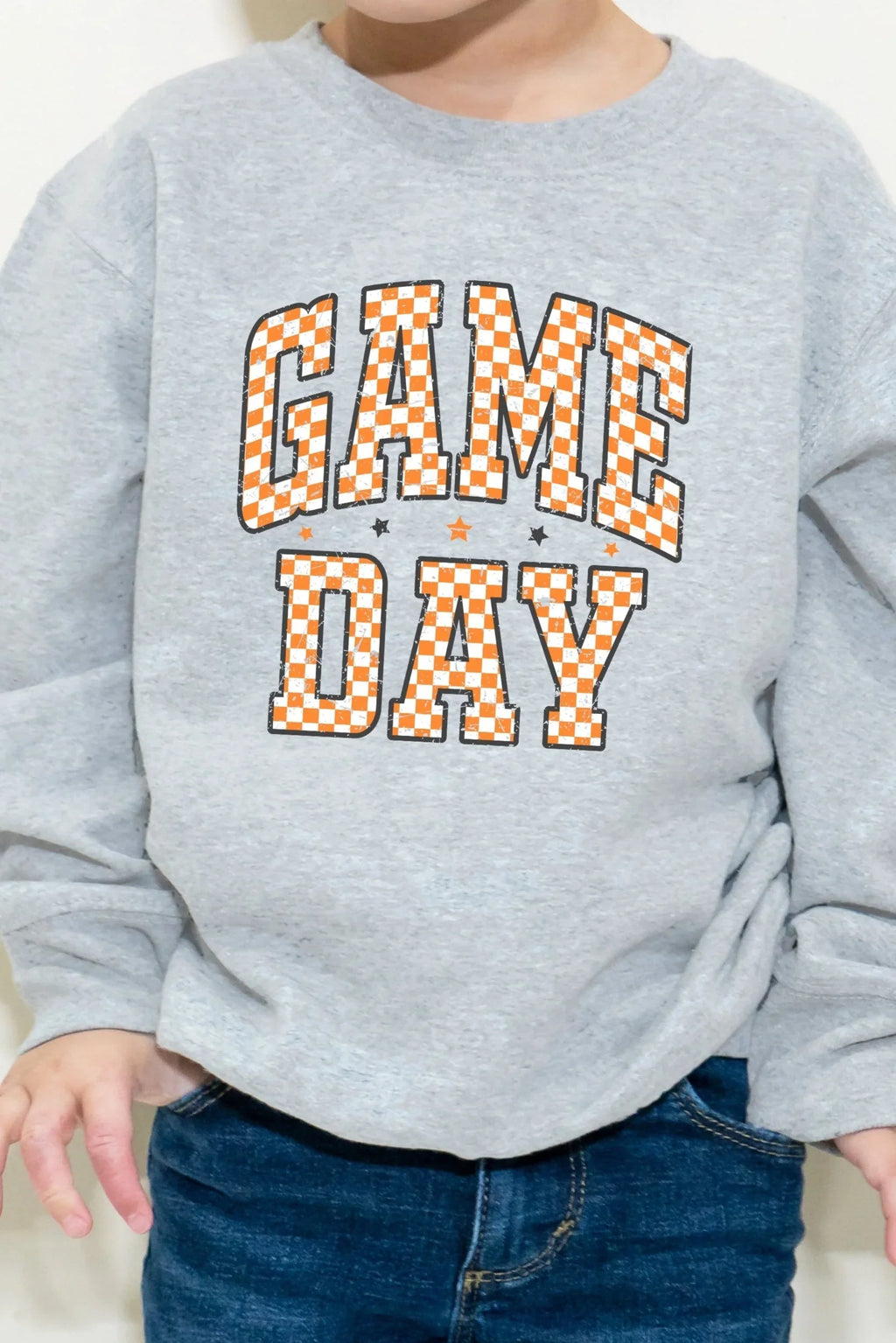 Child wearing a gray sweatshirt with 'GAME DAY' text on a white background