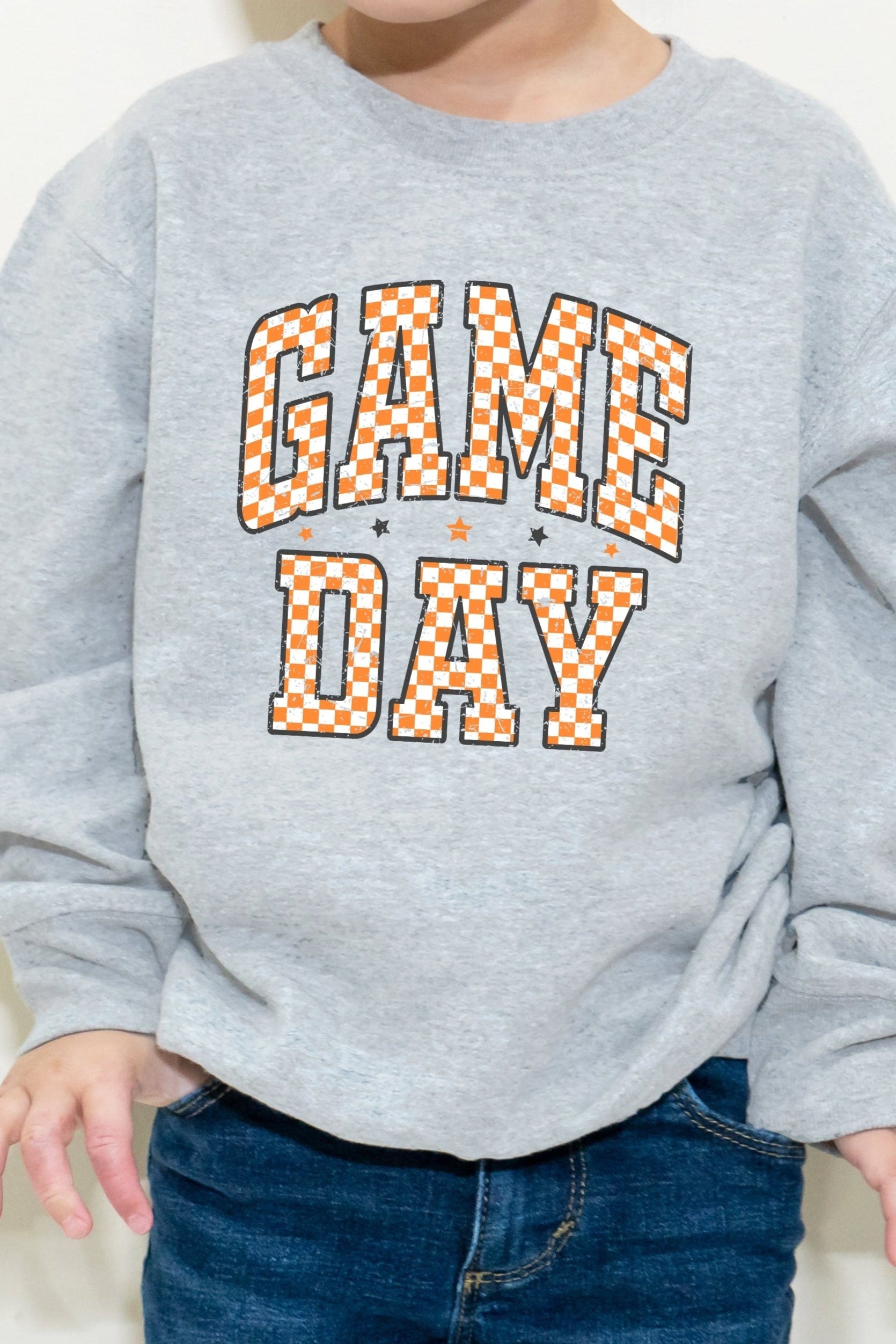Child wearing a gray sweatshirt with 'GAME DAY' text on a white background