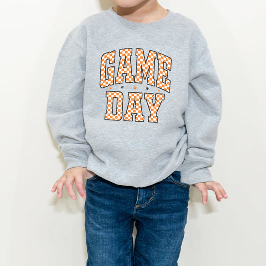 Child wearing a gray sweatshirt with 'GAME DAY' text on a white background