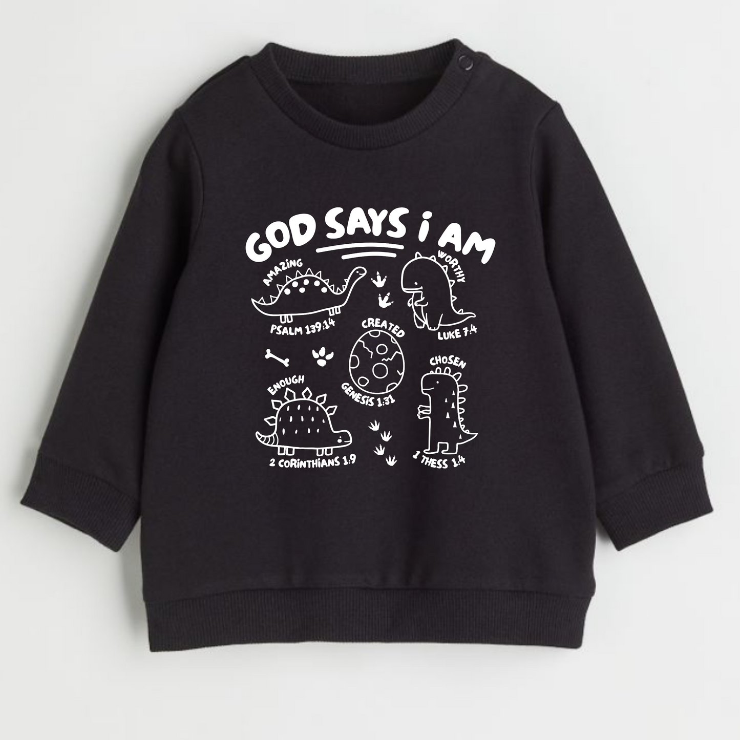 Black faith based sweatshirt with white text and dinosaur graphics and scripture on a light gray background