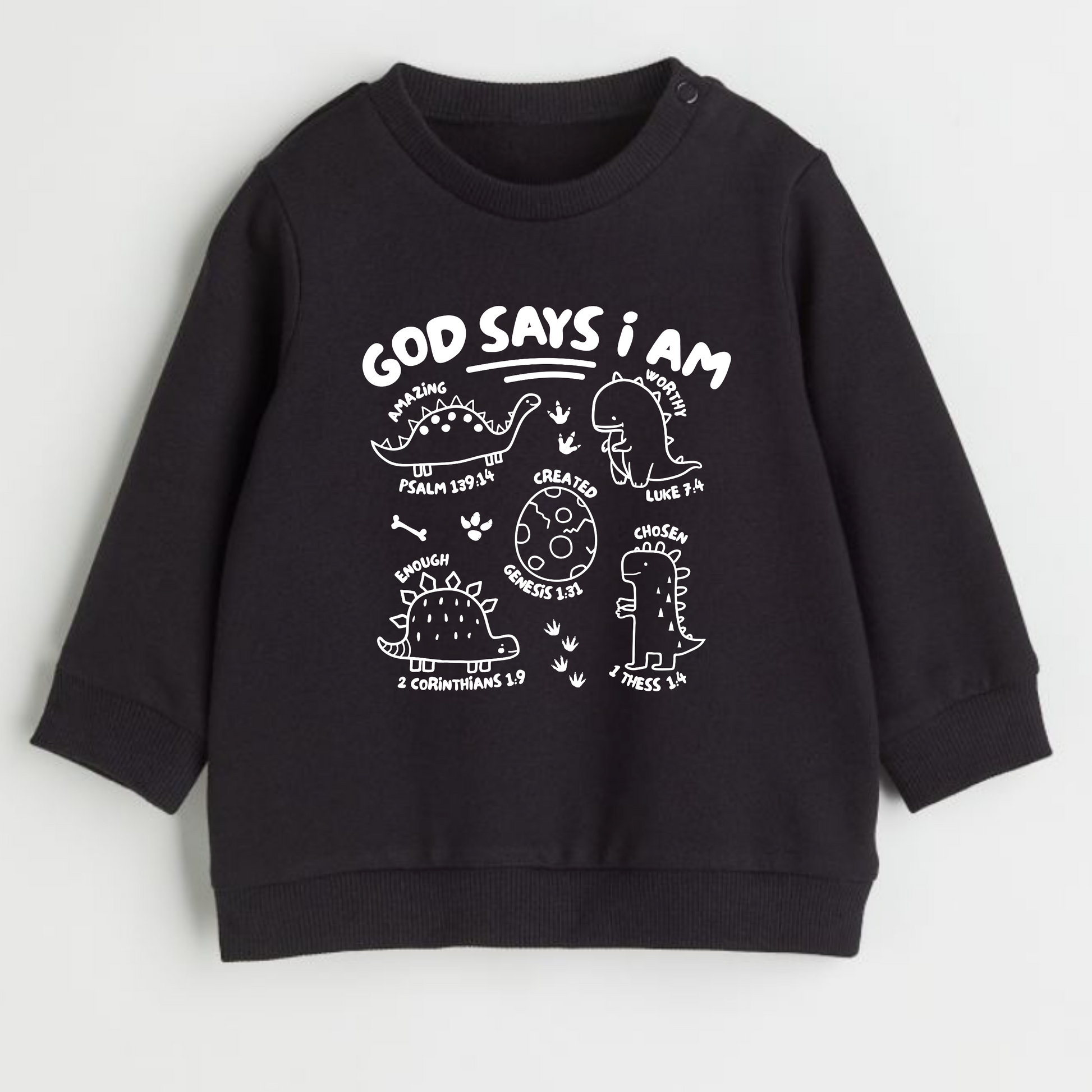 Black faith based sweatshirt with white text and dinosaur graphics and scripture on a light gray background