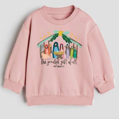 Pink sweatshirt with nativity scene design and text on a light gray background