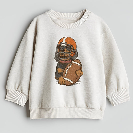 Children's sweatshirt with a graphic of a dog wearing a football helmet and holding a football on a light gray background.
