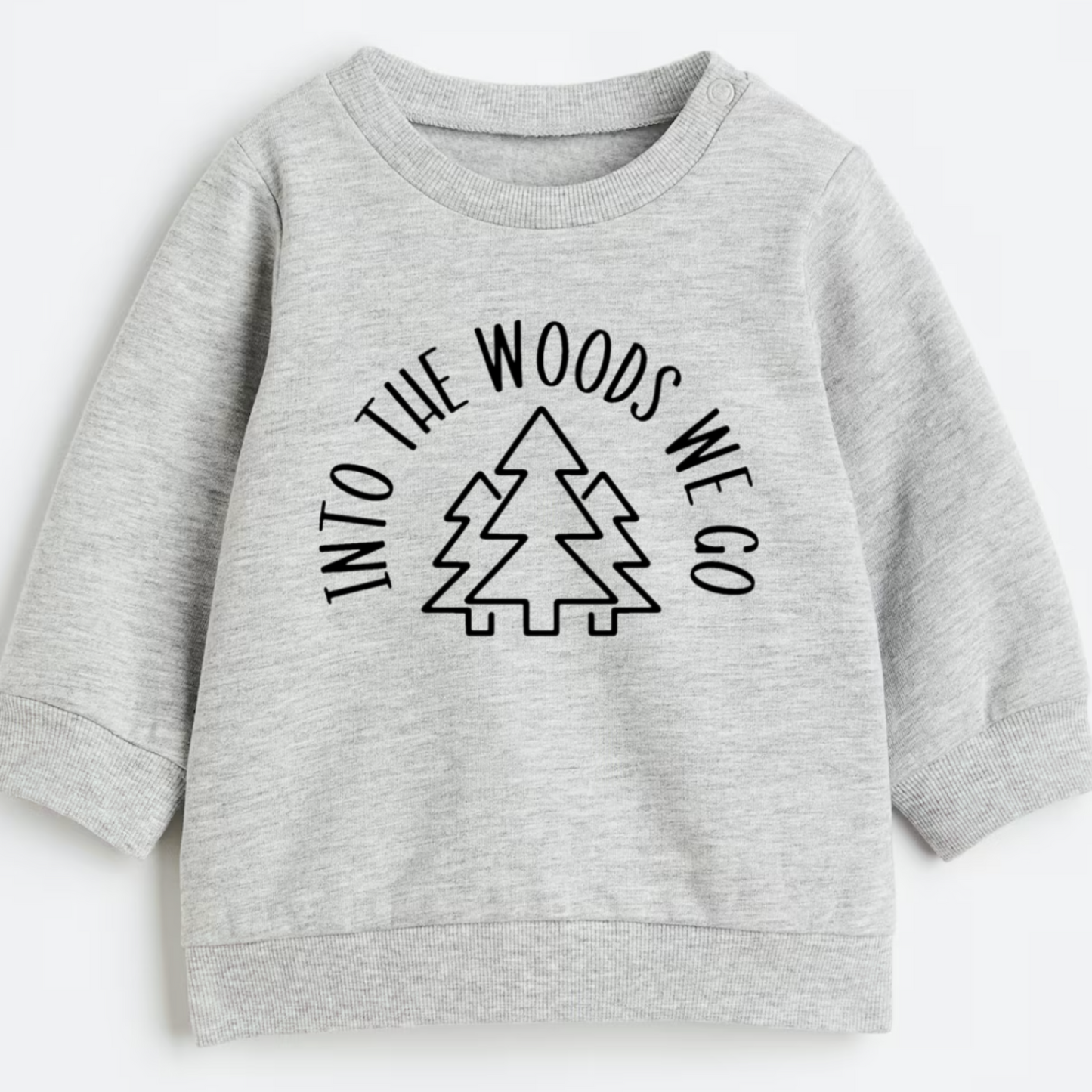 Gray sweatshirt with 'Into the Woods We Go' text and tree graphic on a white background