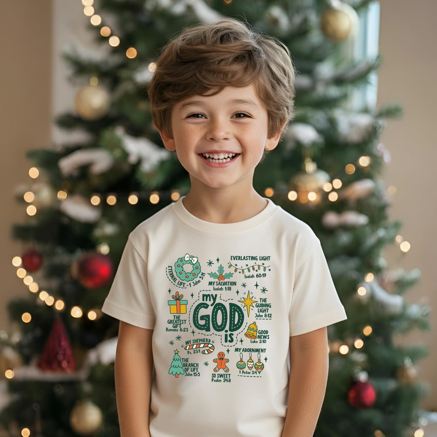 Child wearing a white t-shirt with a colorful design in front of a decorated Christmas tree.