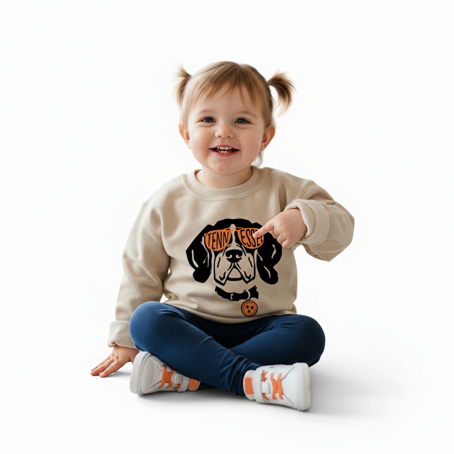 Child wearing a beige sweatshirt with a tennessee dog graphic and text on a white background