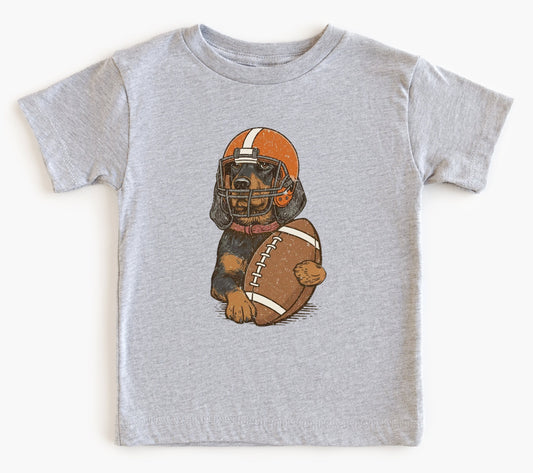 Gray t-shirt with a graphic of a dog wearing a football helmet and holding a football on a white background